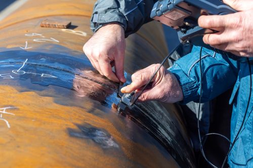 Inspector is testing to weld of pipe with ultrasonic test method